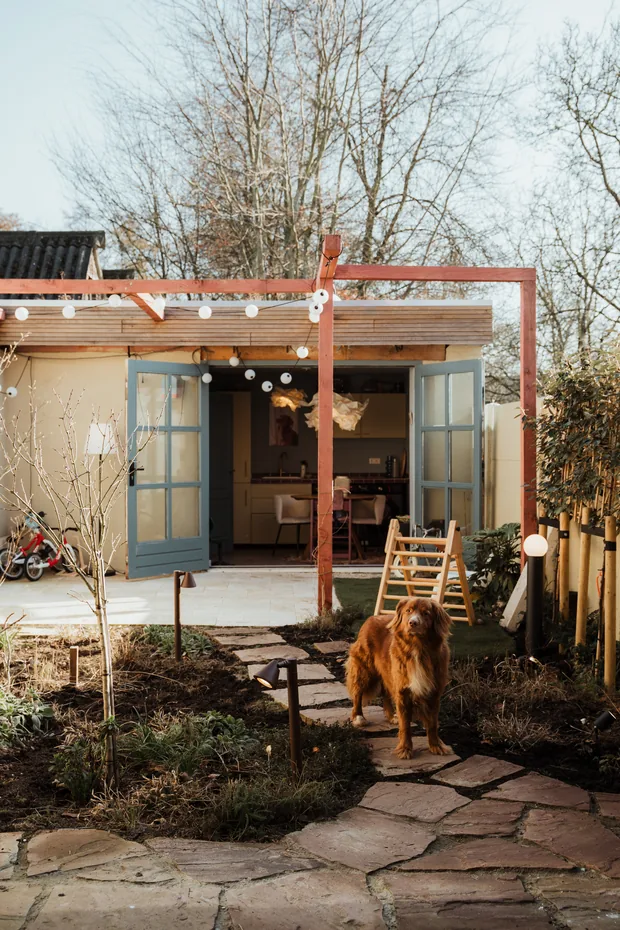 De tuinzijde met houten pergola en natuurstenen pad